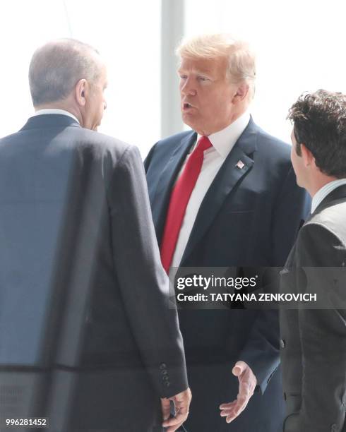 President Donald Trump talks with Turkey's President Recep Tayyip Erdogan as they arrive for the NATO summit, at the NATO headquarters in Brussels,...