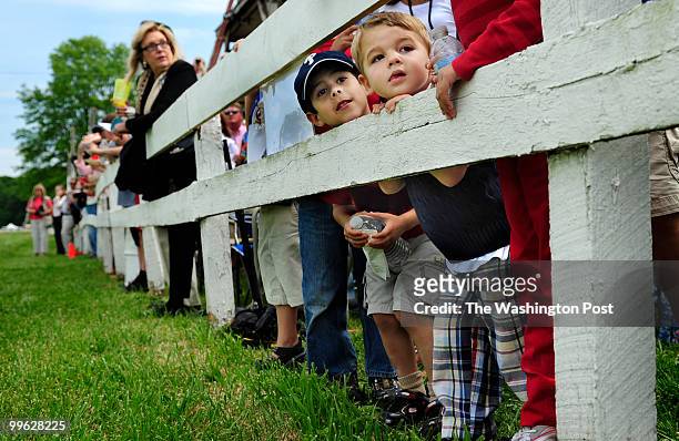 Andres Quesnel, 5 and Zac Johnson, 2 watch the open timber races from the 2nd wrung of the fence at the annaul Potomac Hunt Club races in...