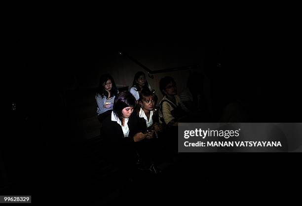 Guests and hotel staff sit in dark in the basement of the Dusit Thani hotel after they were evacuated following an explosion and gunfire were heard...