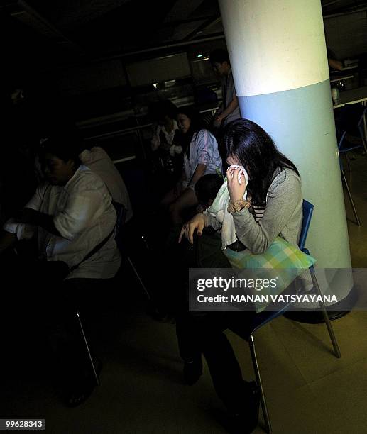 Guest breaks down as she sits in the dark of the basement of the Dusit Thani hotel after they were evacuated following an explosion and gunfire were...