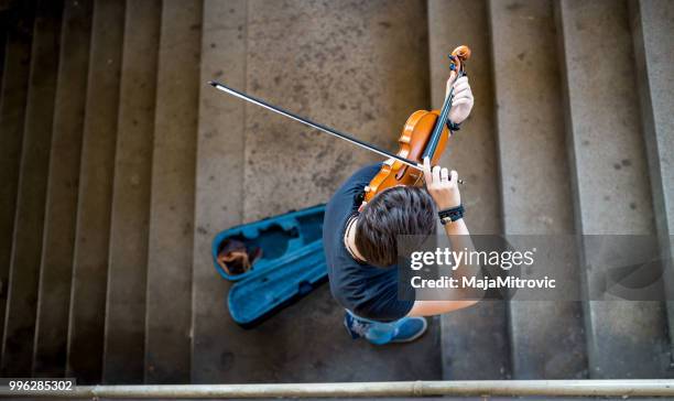 street musician playing violin - sad musician stock pictures, royalty-free photos & images