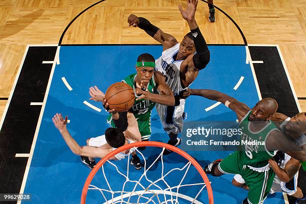 Rajon Rondo of the Boston Celtics takes the ball to the basket against JJ Redick and Dwight Howard of the Orlando Magic in Game One of the Eastern...