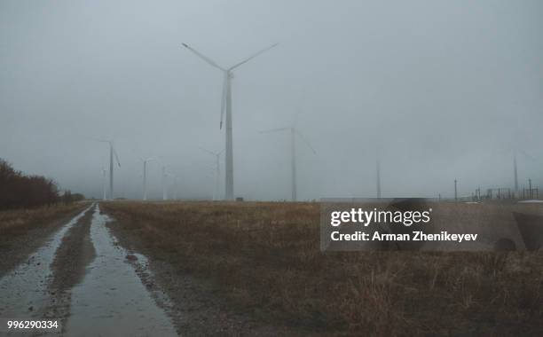 wind turbines in the fog - arman zhenikeyev stock pictures, royalty-free photos & images