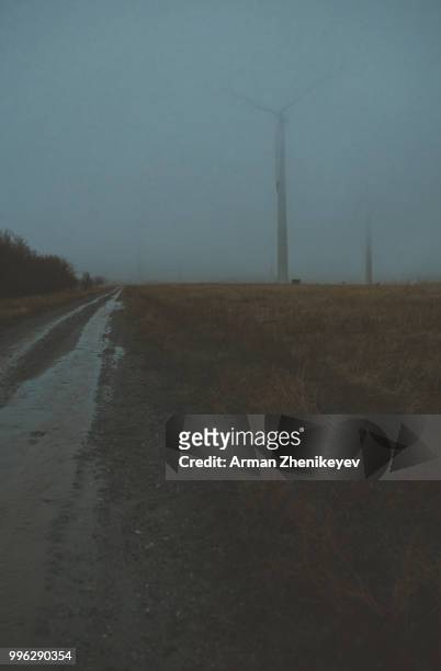 wind turbines in the fog - arman zhenikeyev stock-fotos und bilder