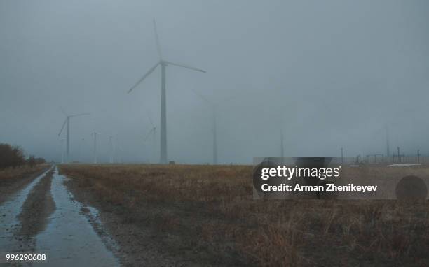 wind turbines in the fog - arman zhenikeyev photos et images de collection