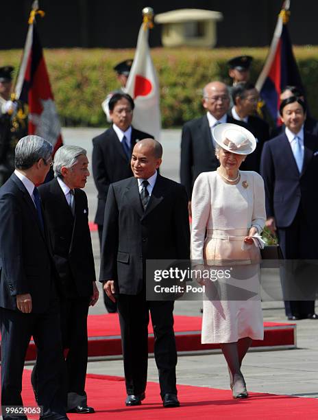 King Norodom Sihamoni of Cambodia chats with Japanese Emperor Akihito while walking with Empress Michiko during his welcoming ceremony at the...