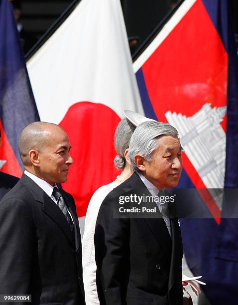 King Norodom Sihamoni of Cambodia and Emperor Akihito of Japan walk in front of Japanese and Cambodian national flags during a welcoming ceremony at...