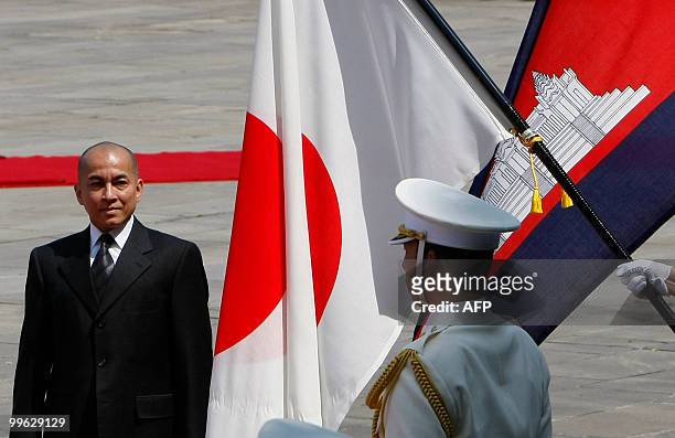 Cambodian King Norodom Sihamoni walks in front of Japanese and Cambodian national flags during a welcoming ceremony at the Imperial Palace in Tokyo...