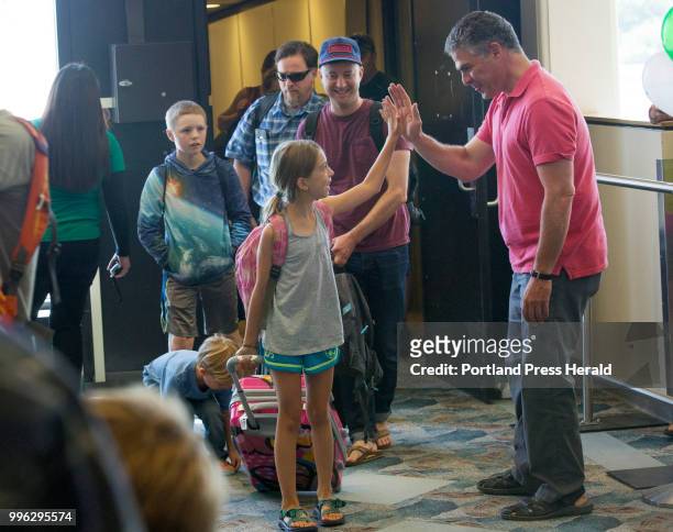 Lila Storch of Boulder, CO gets a high-five from Mayor Ethan Strimling as he greets passengers departing Frontier Airlines's first ever flight to...