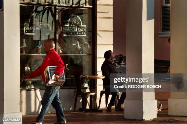 People sit outside the Olympia Cafe, a popular eatery and bakery in Kalk Bay, a trendy fishing village, about 30km from the city centre, on July 11...