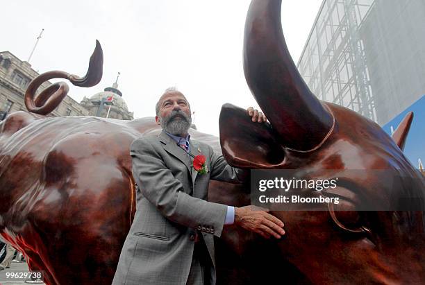 Artist Arturo Di Modica poses next to his Charging Bull statue, a version of which is also installed near New York City's Wall Street financial...