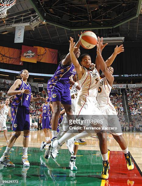 Tanisha Wright and Camille Little of the Seattle Storm go for a rebound against DeLisha Milton-Jones of the Los Angeles Sparks on May 16, 2010 at Key...
