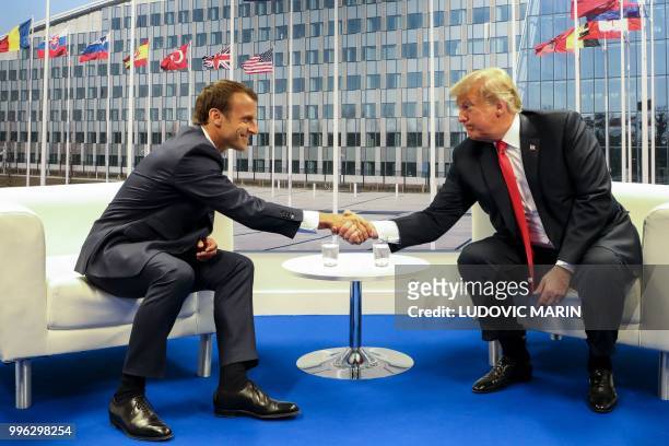 French President Emmanuel Macron and US President Donald Trump shake hands before a bilateral meeting on the sidelines of the NATO summit, at the...