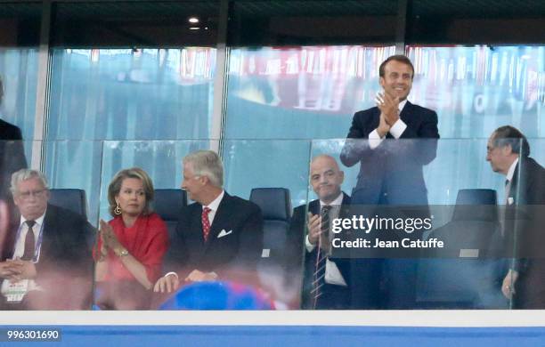 President of France Emmanuel Macron stands while King Philippe of Belgium, Queen Mathilde of Belgium, FIFA President Gianni Infantino stay seated...