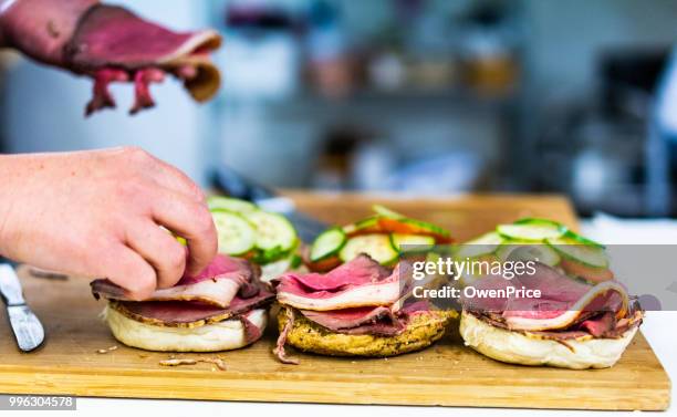 voedselbereiding in traditionele britse slagers winkel. - een broodje smeren stockfoto's en -beelden