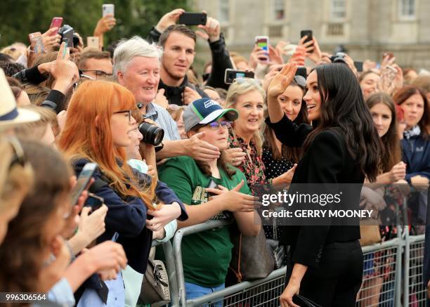 Britain's Meghan, Duchess of Sussex greets well-wishers after her visit with Britain's Prince Harry, Duke of Sussex to Trinity College in Dublin on...