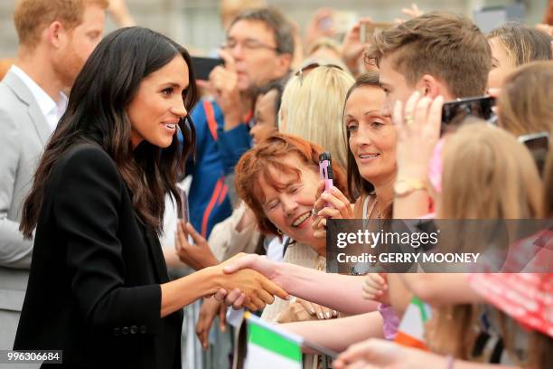 Britain's Meghan, Duchess of Sussex greets well-wishers after her visit with Britain's Prince Harry, Duke of Sussex to Trinity College in Dublin on...