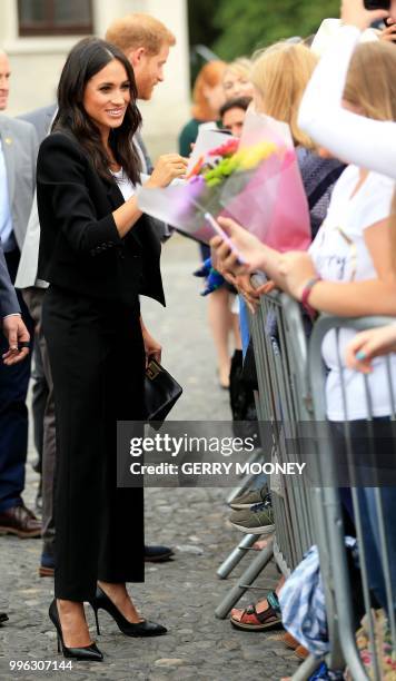 Britain's Meghan, Duchess of Sussex greets well-wishers after her visit with Britain's Prince Harry, Duke of Sussex to Trinity College in Dublin on...