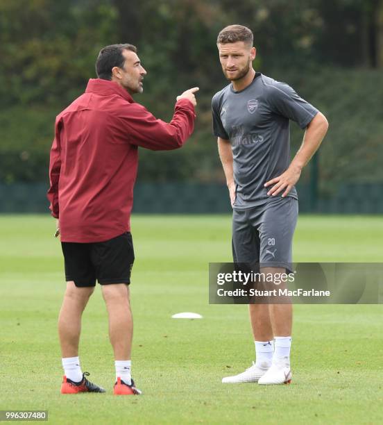 Arsenal assistant coach Juan Carlos Carcedo talks to Shkodran Mustafi during a training session at London Colney on July 11, 2018 in St Albans,...