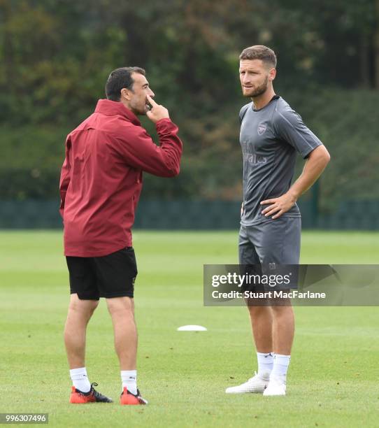 Arsenal assistant coach Juan Carlos Carcedo talks to Shkodran Mustafi during a training session at London Colney on July 11, 2018 in St Albans,...