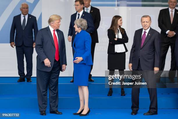 President Donald Trump talks with British Prime Minister Theresa May as Turkish President Recep Tayyip Erdogan looks on at the 2018 NATO Summit at...