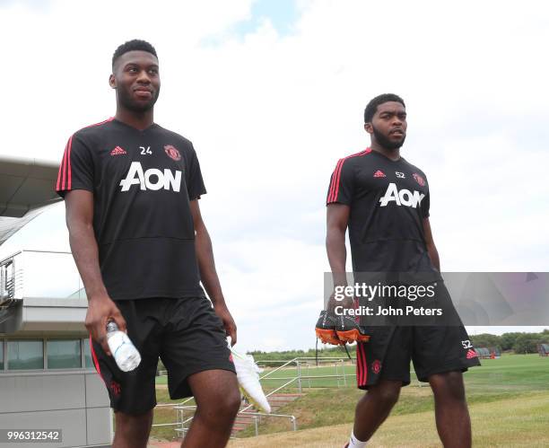 Timothy Fosu-Mensah and Ro-Shaun Williams of Manchester United walk out ahead of a first team training session at Aon Training Complex on July 11,...