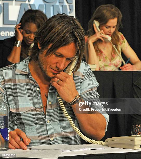 Country singer Keith Urban works the phone bank during the "Music City Keep on Playin'" benefit concert at the Nashville Convention center on May 16,...