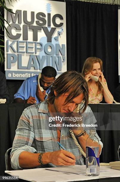 Country singer Kieth Urban works the phone bank during the "Music City Keep on Playin'" benefit concert at the Nashville Convention center on May 16,...