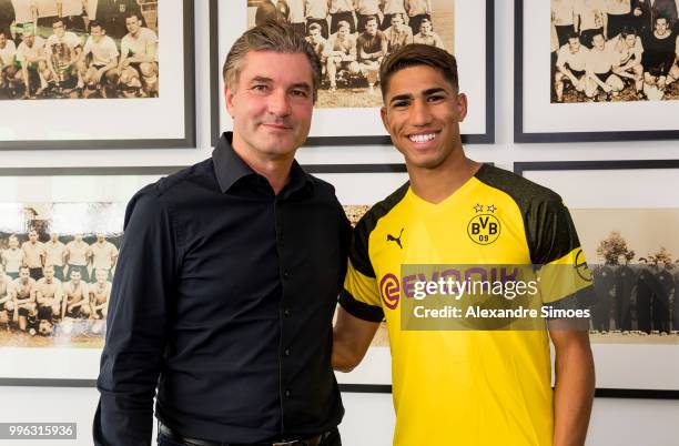 Achraf Hakimi signs a new contract with Borussia Dortmund and Michael Zorc at Dortmund on July 11, 2018 in Dortmund, Germany.