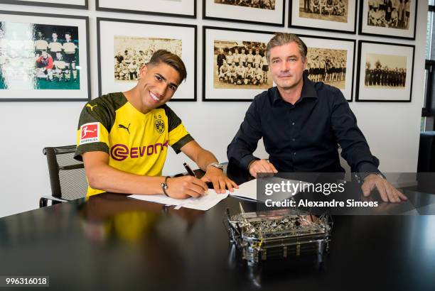 Achraf Hakimi signs a new contract with Borussia Dortmund and Michael Zorc at Dortmund on July 11, 2018 in Dortmund, Germany.