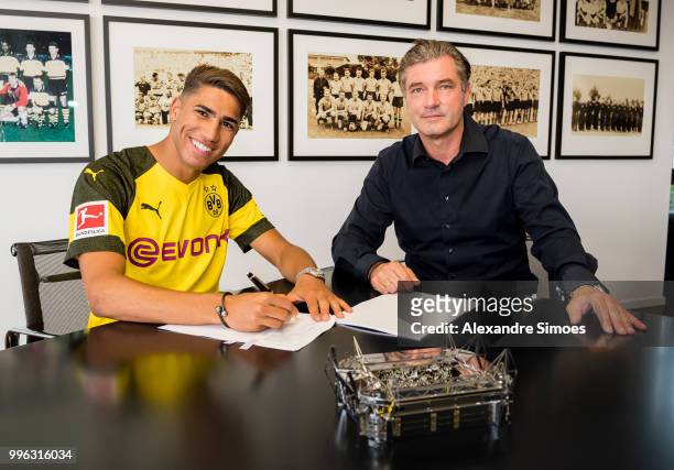 Achraf Hakimi signs a new contract with Borussia Dortmund and Michael Zorc at Dortmund on July 11, 2018 in Dortmund, Germany.
