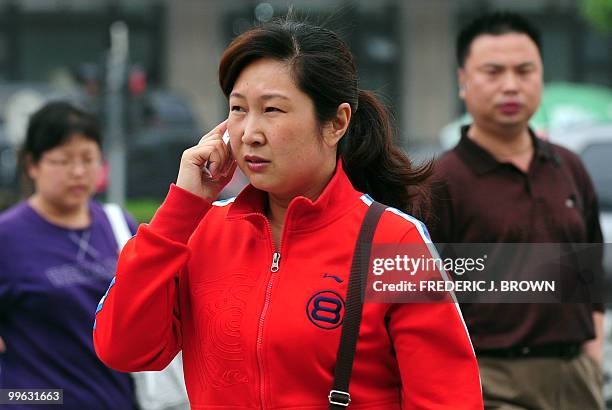 Woman speaks on her mobile phone along a street in Beijing on May 17, 2010. The largest study to date of the safety of mobile phones has found no...