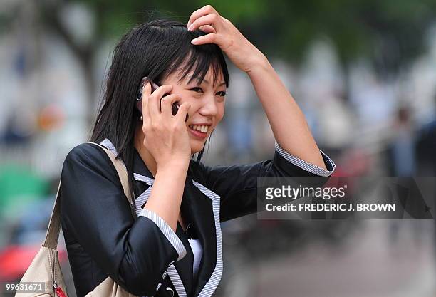 Woman speaks on her mobile phone along a street in Beijing on May 17, 2010. The largest study to date of the safety of mobile phones has found no...