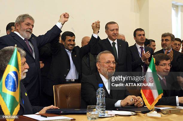 Brazilian President Luiz Inacio Lula da Silva, Iran's President Mahmoud Ahmadinejad, Turkish Prime Minister Recep Tayyip Erdogan raise their hands...