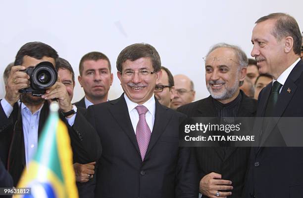 Iranian President Mahmoud Ahmadinejad takes a picture as he poses next to Turkish Prime Minister Recep Tayyip Erdogan , Iran's Nuclear Chief Ali...