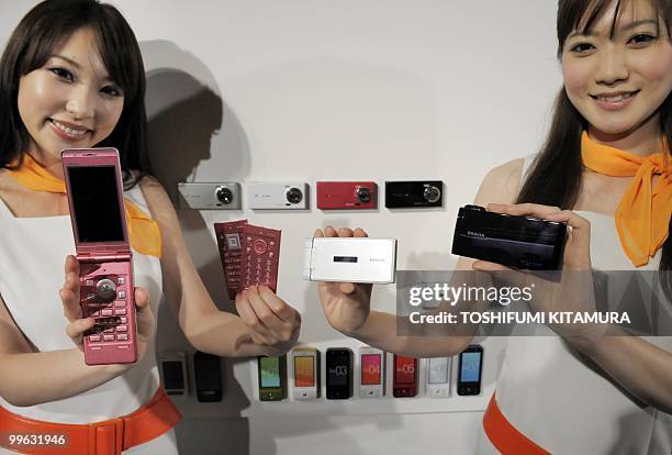 Models shows off KDDI's brand, AU's new 2010 summer models of moble handsets during their press preview in Tokyo on May 17, 2010. KDDI introduced...