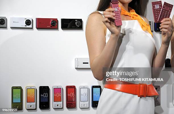 Models shows off KDDI's brand, AU's new 2010 summer models of moble handsets during their press preview in Tokyo on May 17, 2010. KDDI introduced...