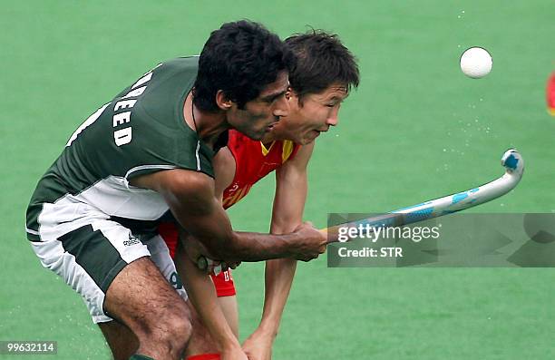 Pakistani field hockey player Ahmed Fareed vies for the ball with Chinese player Meng Jun during their match in the Sultan Azlan Shah Cup field...