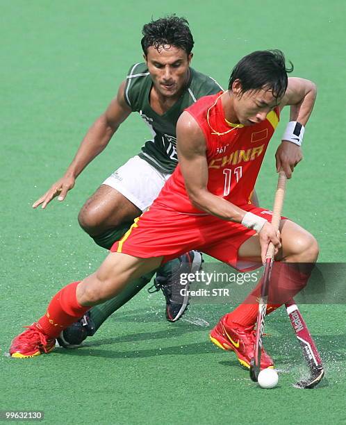 Pakistani field hockey player Muhammad Kashif Ali and Chinese player Lu Fenghui vie for the ball during their match in the Sultan Azlan Shah Cup...