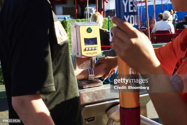 An employee scans a customer's amusement park ride pass at Luna Park in Coney Island in the Brooklyn Borough of New York, U.S., on Saturday, July 7,...