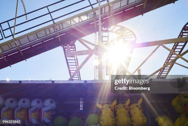 Game prizes hang from a booth in front of the Thuderbolt roller coaster at Luna Park in Coney Island in the Brooklyn Borough of New York, U.S., on...