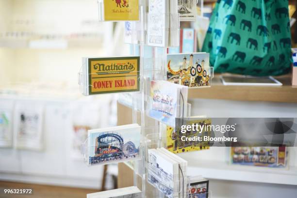 Souvenir postcards sit on display for sale at a store on the Coney Island boardwalk in the Brooklyn Borough of New York, U.S., on Saturday, July 7,...