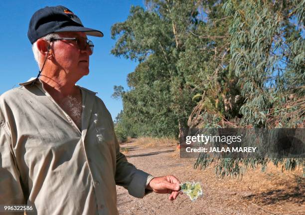 An Israeli man holds debris as Israeli forces search the Sea of Galilee coasts for the remains of a reported drone launched from Syria and...