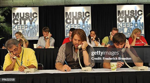 Country singers James Otto, center, and Dave Haywood, work the phone bank during the "Music City Keep on Playin'" benefit concert at the Nashville...