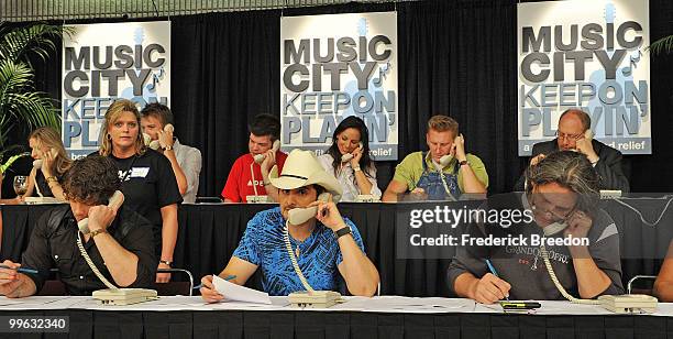 Country singers, including Brad Paisley, front row center, works the phone bank during the "Music City Keep on Playin'" benefit concert at the...