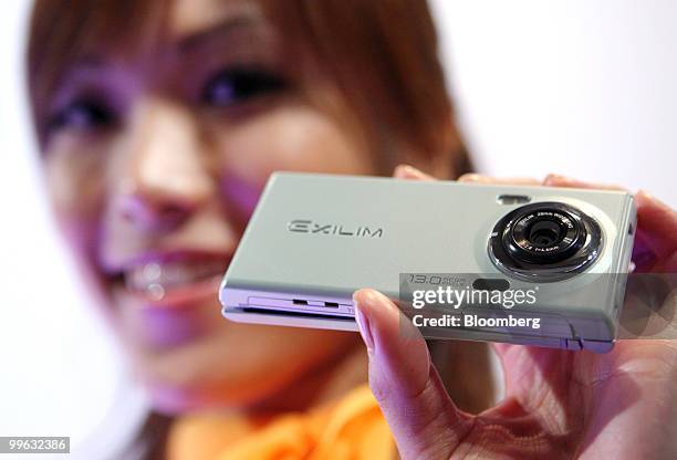 Model poses with KDDI Corp.'s latest au brand Exilim CA005mobile phone manufactured by Casio Computer Co. At their unveiling in Tokyo, Japan, on...