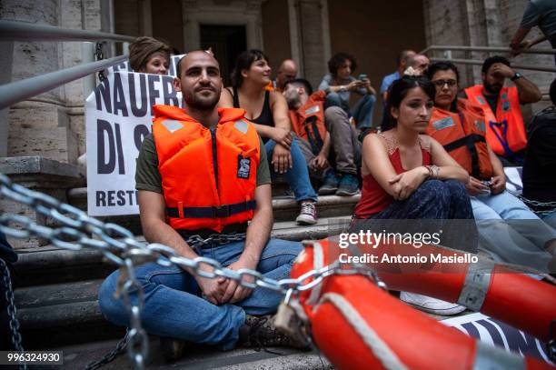 Dozens of protesters wearing life jackets chained themselves outside the Ministry of Transport during a protest against the Italian immigration...