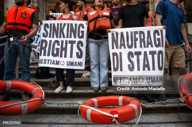 Dozens of protesters wearing life jackets chained themselves outside the Ministry of Transport during a protest against the Italian immigration...
