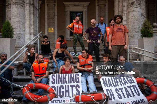 Dozens of protesters wearing life jackets chained themselves outside the Ministry of Transport during a protest against the Italian immigration...