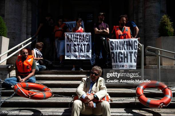 Dozens of protesters wearing life jackets chained themselves outside the Ministry of Transport during a protest against the Italian immigration...